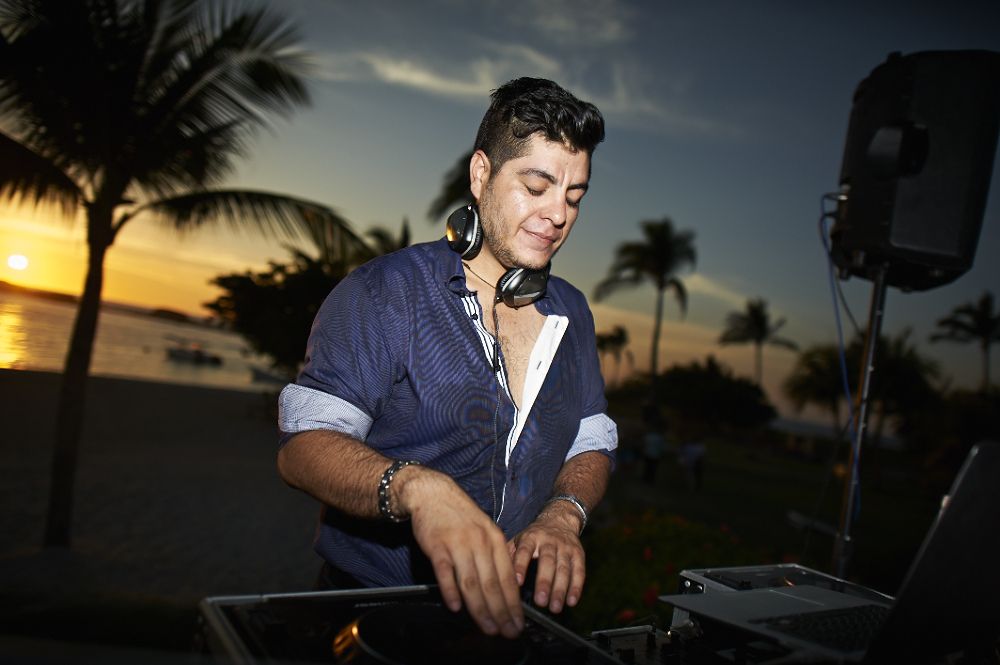 Mau Lemus at the decks at sunset between the palms