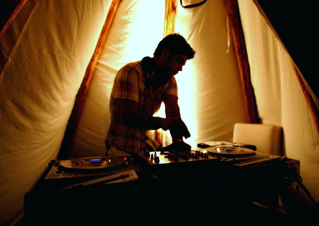 Silhouette in a beach teepee DJ booth